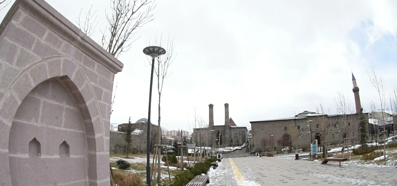 Karlı bir Erzurum caddesinde minareler önünde tarihî çeşme; belediyenin çeşme filminden kare